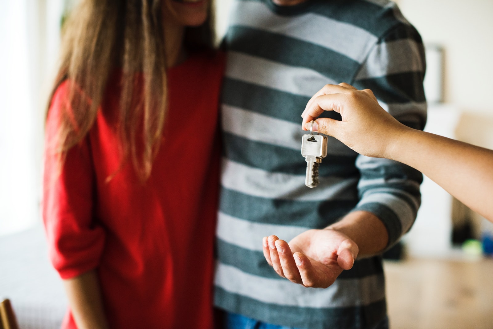 A young couple receiving keys to their new home